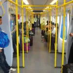 Une rame de l'Airport Rail Link à quai dans une gare de Bangkok, avec des passagers sur le quai.