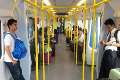 Une rame de l'Airport Rail Link à quai dans une gare de Bangkok, avec des passagers sur le quai.
