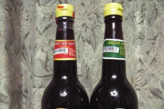 Deux bouteilles de sauce soja indonésienne cote à cote, kecap manis sucré et kecap asin salé