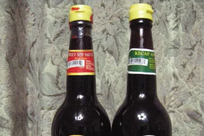 Deux bouteilles de sauce soja indonésienne cote à cote, kecap manis sucré et kecap asin salé