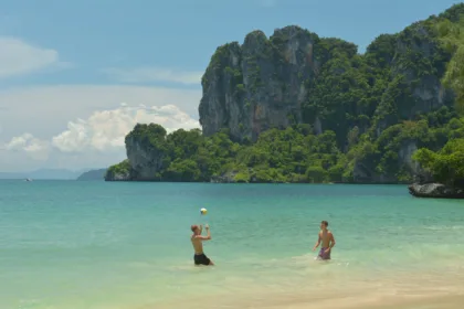 Une partie de volley sur la plage d'Ao Nang, à Krabi, devant les falaises calcaires