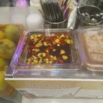 Un bol de nam pla prik, piments rouges et verts émincés dans la sauce de poisson, posé sur une table thaïlandaise