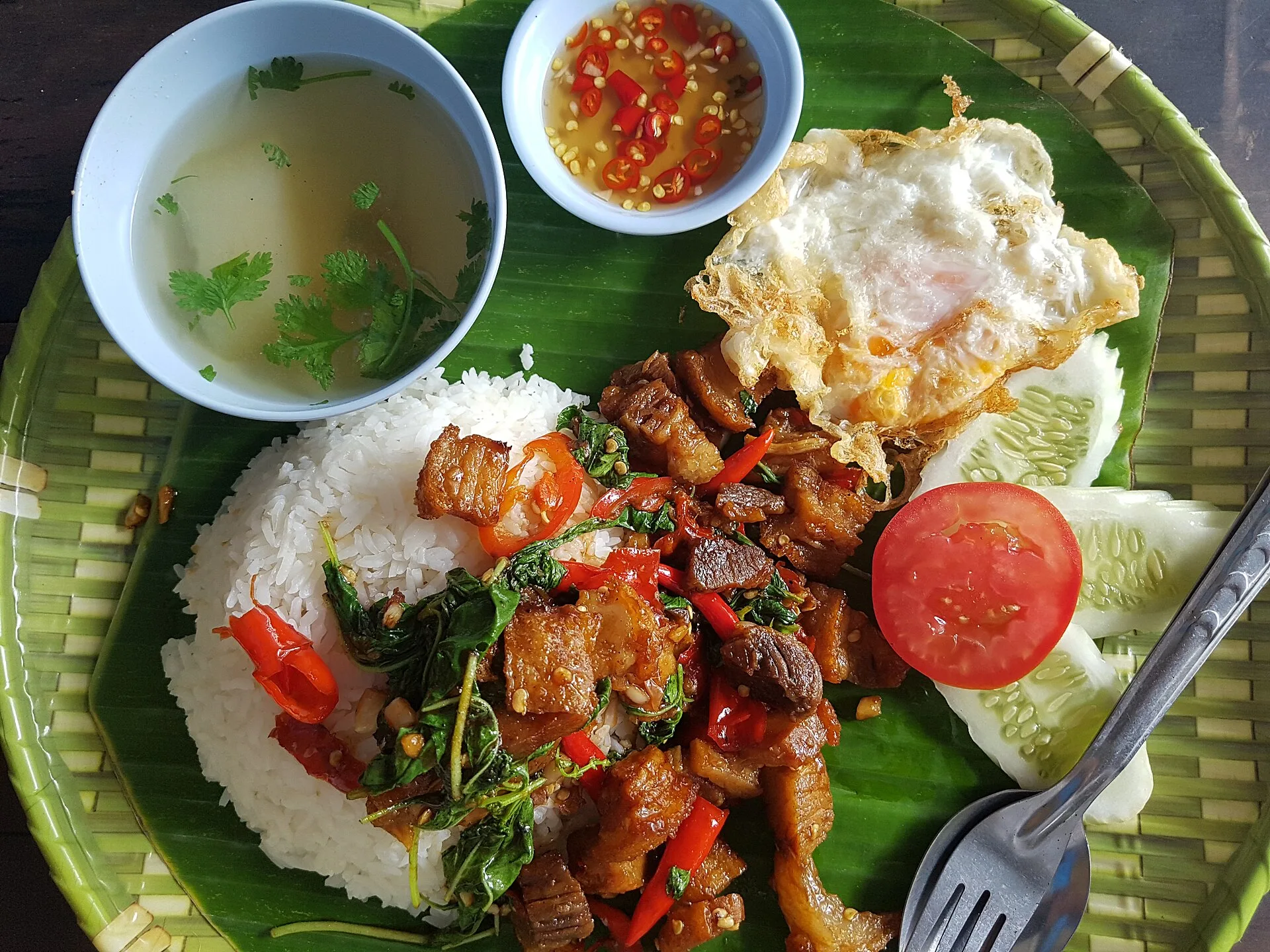 Nam pla prik : la sauce piment thaïlandaise de tous les jours 8 Un plateau thaïlandais avec porc au basilic, riz, œuf au plat et un bol de nam pla prik