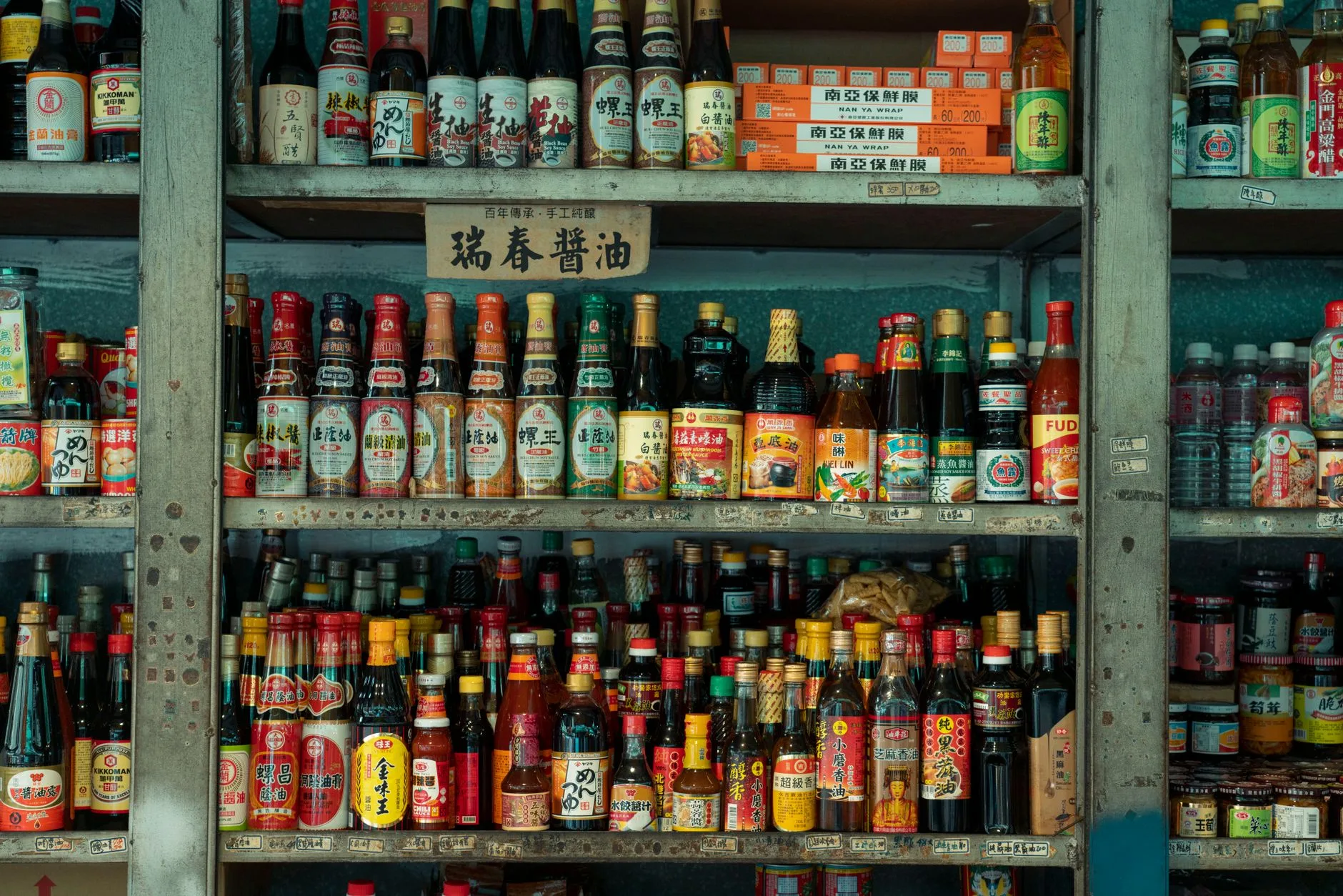 Sauce hoisin : ce qu'il y a dedans et comment l'utiliser 8 Un rayon de sauces et condiments asiatiques en bouteilles, sur une étagère de marché