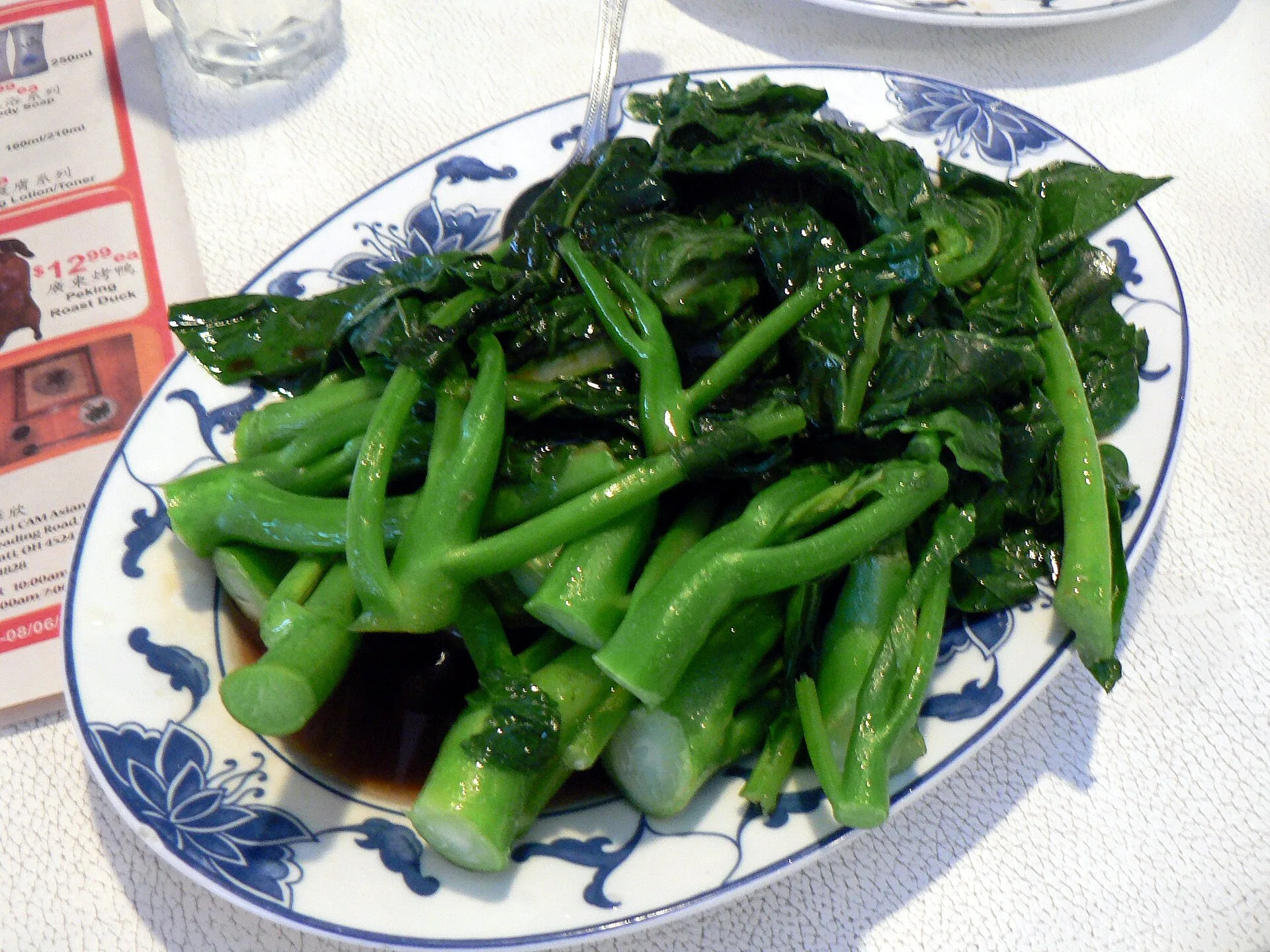 Sauce d'huître : à quoi elle sert vraiment en cuisine asiatique 9 Des tiges de chou chinois cuites et nappées d'une sauce brune brillante