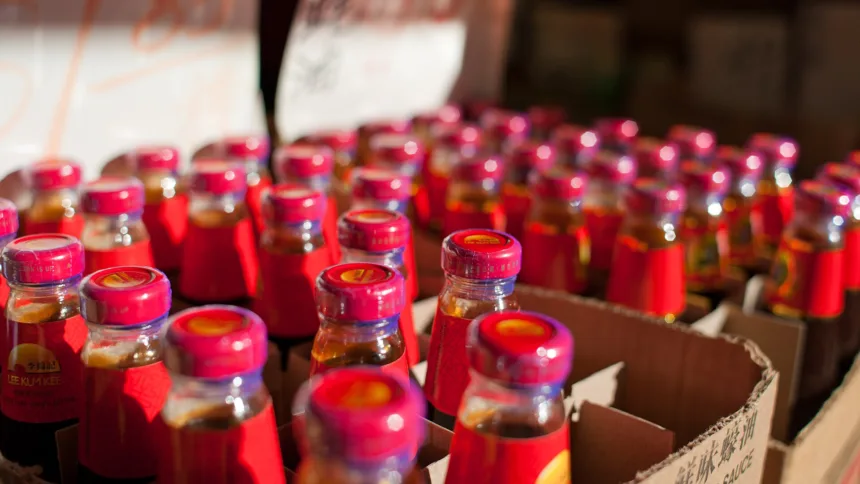 Une bouteille de sauce d'huître brune posée près d'un wok