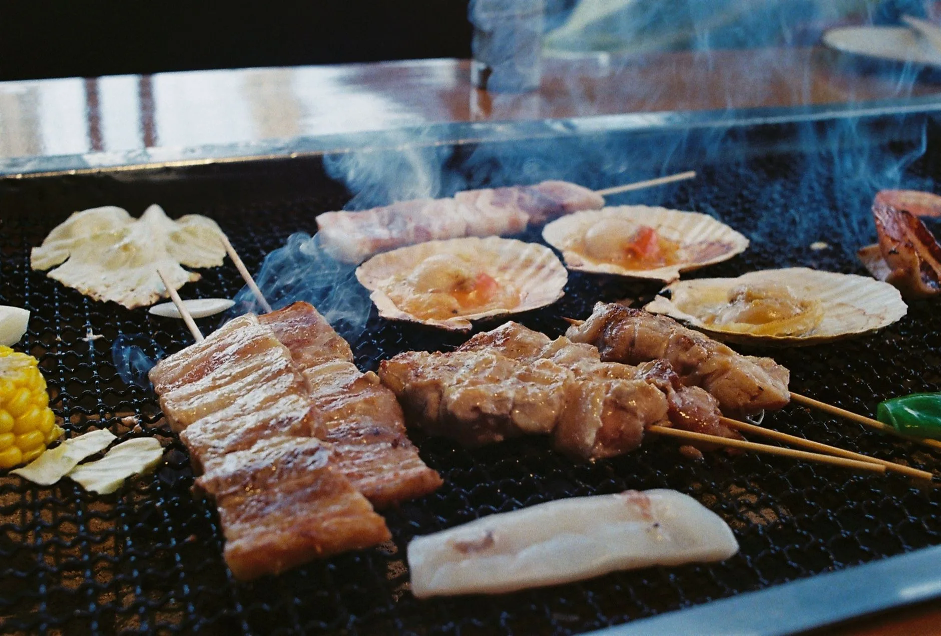 Des brochettes et des fruits de mer grillés sur un barbecue ouvert, au Japon