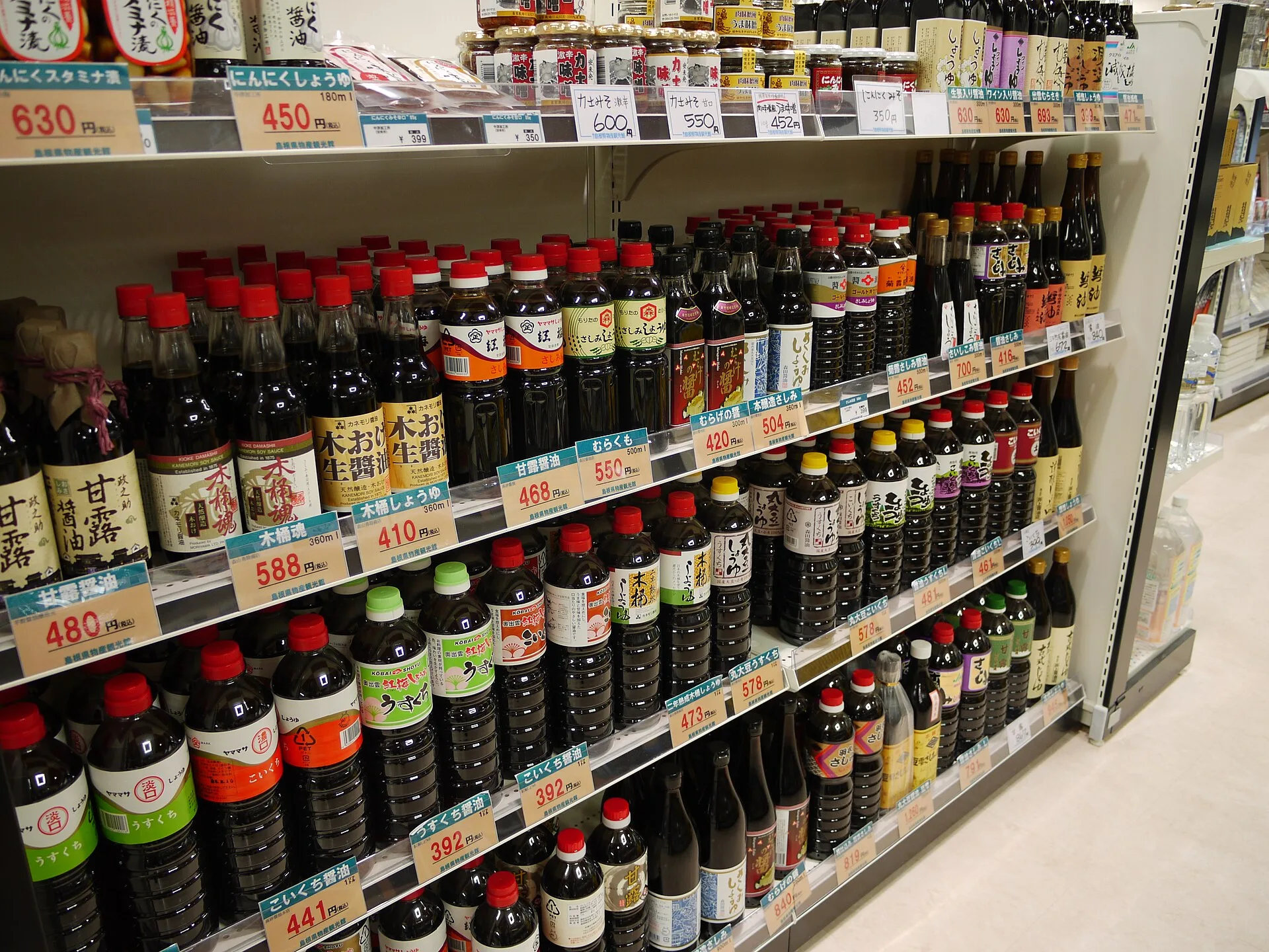 Plusieurs bouteilles de sauce soja japonaise alignées sur une étagère
