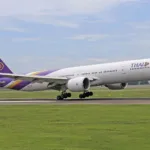 Un Boeing 777 de Thai Airways à l'atterrissage sur la piste d'un aéroport