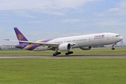 Un Boeing 777 de Thai Airways à l'atterrissage sur la piste d'un aéroport