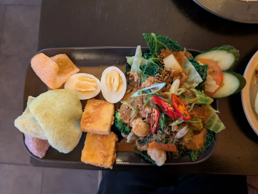Une assiette de gado-gado, légumes tièdes, tofu et oeuf dur nappés d'une sauce cacahuète brune