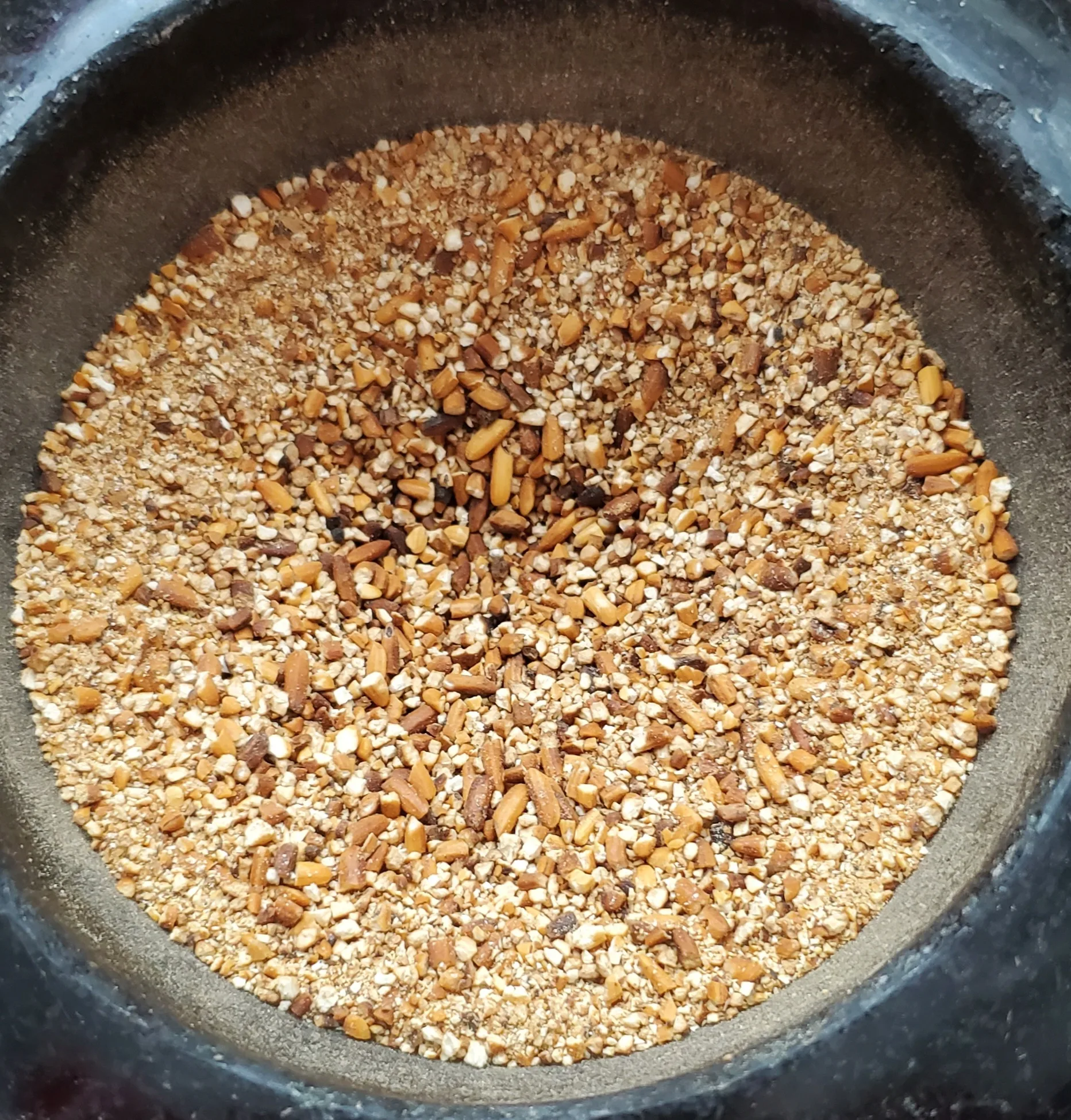 Une poudre de riz grillé brun doré, grossièrement moulue, dans un récipient